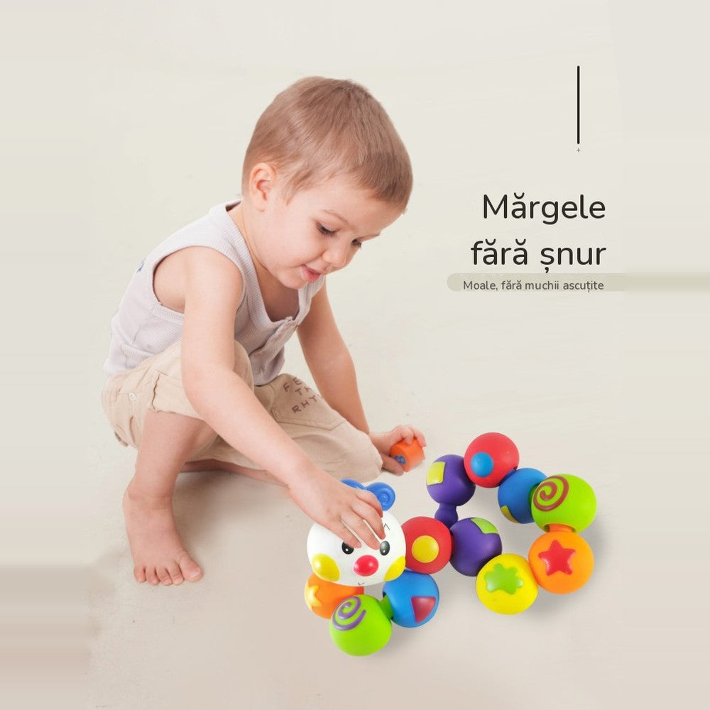 Băiețel care construiește pe podea omida LUDIRO din piese colorate, cu textul Mărgele fără șnur