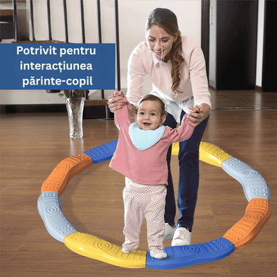 Adult care sprijină un copil în timpul pășirii pe un traseu de echilibru colorat.